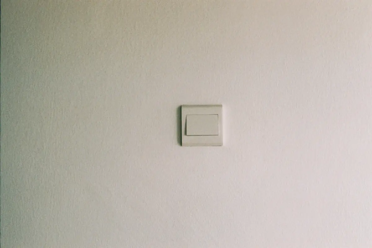 Witte lichtschakelaar op een lichte muur